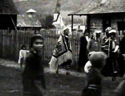 people walking on boardwalk wearing traditional Indigenous attire